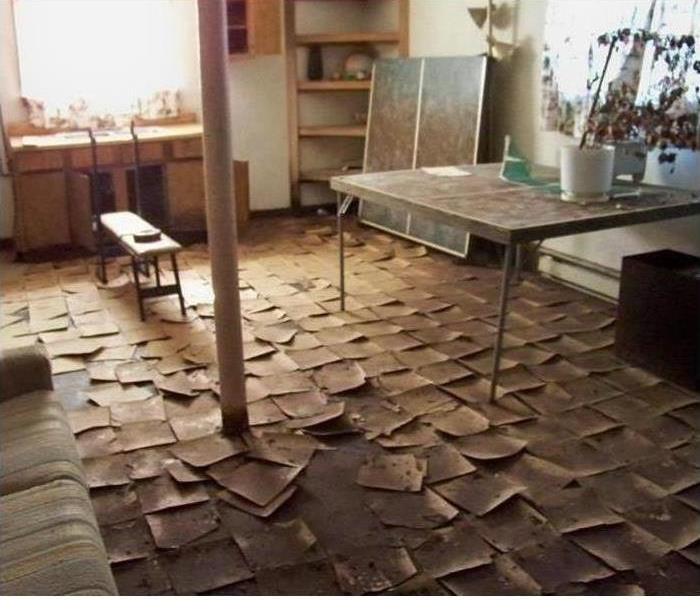 Room with peeled up tiles and furniture