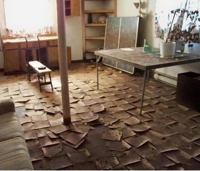 Room with game tables and damaged tile floor