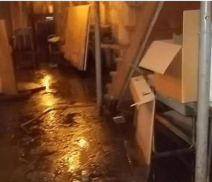 Basement with standing water around boxes and chairs