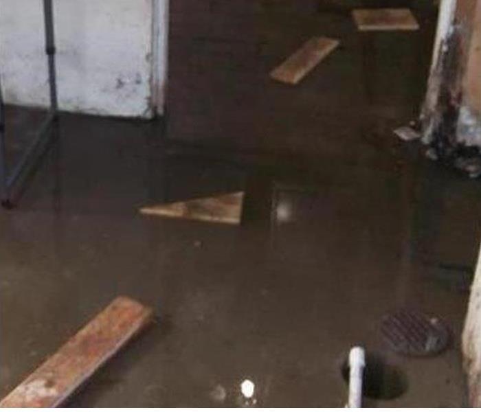 Basement with pieces of wood floating in standing water